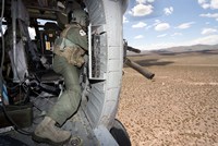 Framed HH-60G Pave Hawk gunner fires his GAU-17 machine gun
