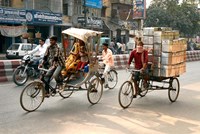 Framed People and cargo move through streets via rickshaw, Varanasi, India