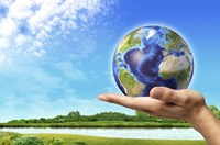 Framed Human Hand Holding Earth Globe with a Green Landscape Background