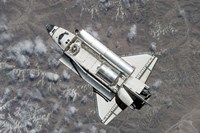 Framed Aerial view of Space Shuttle Discovery over Earth as it approaches the International Space Station