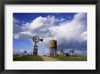 Framed Low angle view of a water tower and an industrial windmill, 1880 Town, South Dakota, USA
