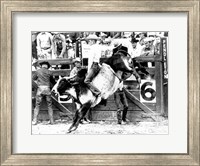 Framed Side profile of a cowboy riding a bull at a rodeo