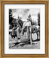 Framed Teenage cowboys sitting on rail fence