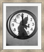 Framed Close-up of the shadow of a person carrying a scythe on a clock