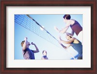 Framed Low angle view of two young couples playing beach volleyball