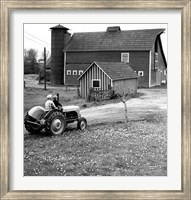 Framed Man with a Boy Riding a Tractor in a Field