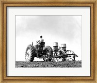 Framed Low Angle View of a Farmer Planting Corn with a Tractor in a Field