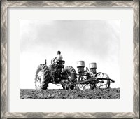 Framed Low Angle View of a Farmer Planting Corn with a Tractor in a Field