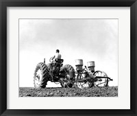 Framed Low Angle View of a Farmer Planting Corn with a Tractor in a Field