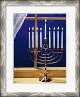 Framed Close-up of burning candles on a menorah at a window