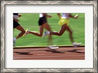 Framed Low section view of male athletes running on a running track