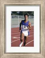 Framed Male athlete running on a running track