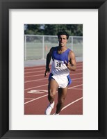 Framed Male athlete running on a running track