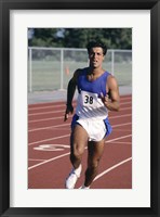 Framed Male athlete running on a running track