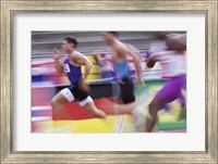 Framed Side profile of three men running on a running track