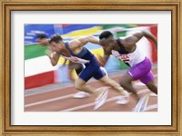 Framed Side profile of three men running low on a running track