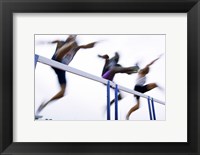 Framed Low angle view of three men jumping over a hurdle