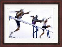 Framed Low angle view of three men jumping over a hurdle