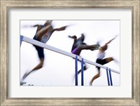 Framed Low angle view of three men jumping over a hurdle