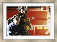 Framed Close-up of a firefighter carrying a boy