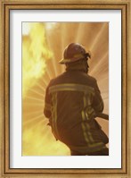 Framed Rear view of a firefighter extinguishing a fire