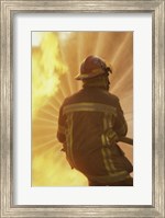 Framed Rear view of a firefighter extinguishing a fire