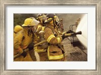 Framed Side profile of a group of firefighters holding water hoses