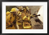 Framed Side profile of a group of firefighters holding water hoses