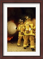 Framed Rear view of three firefighters extinguishing a fire