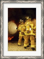 Framed Rear view of three firefighters extinguishing a fire