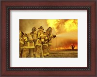 Framed Rear view of a group of firefighters extinguishing a fire