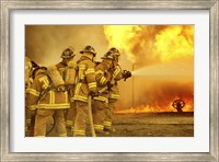 Framed Rear view of a group of firefighters extinguishing a fire