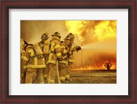 Framed Rear view of a group of firefighters extinguishing a fire