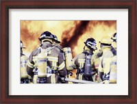 Framed Rear view of a group of firefighters holding water hoses