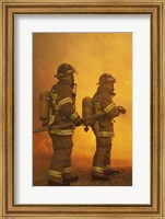 Framed Rear view of two firefighters extinguishing a fire