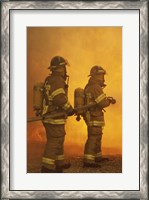 Framed Rear view of two firefighters extinguishing a fire