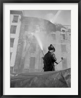 Framed Firefighter pouring water on burning building, low angle view