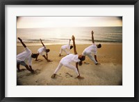 Framed Group of people performing yoga on the beach
