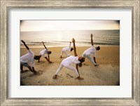 Framed Group of people performing yoga on the beach