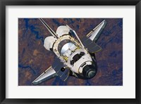 Framed Space Shuttle Discovery approaches the International Space Station