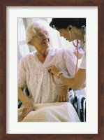 Framed Female nurse checking a female patient's heartbeat