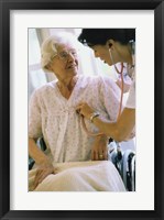 Framed Female nurse checking a female patient's heartbeat