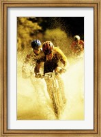 Framed Young men riding bicycles through water