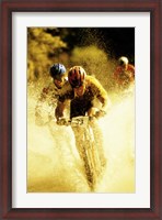 Framed Young men riding bicycles through water