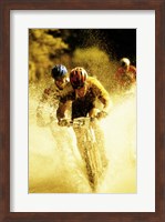 Framed Young men riding bicycles through water