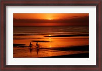 Framed Silhouette of a young couple cycling on the beach