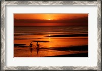 Framed Silhouette of a young couple cycling on the beach