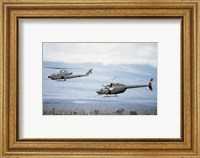 Framed left side view of an AH-1 Cobra helicopter, front, and an OH-58 Kiowa helicopter