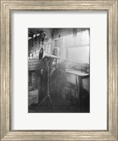 Framed Thomas Alva Edison, full-length portrait, standing, facing right, listening to a new record