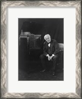 Framed Thomas Edison, seated beside phonograph